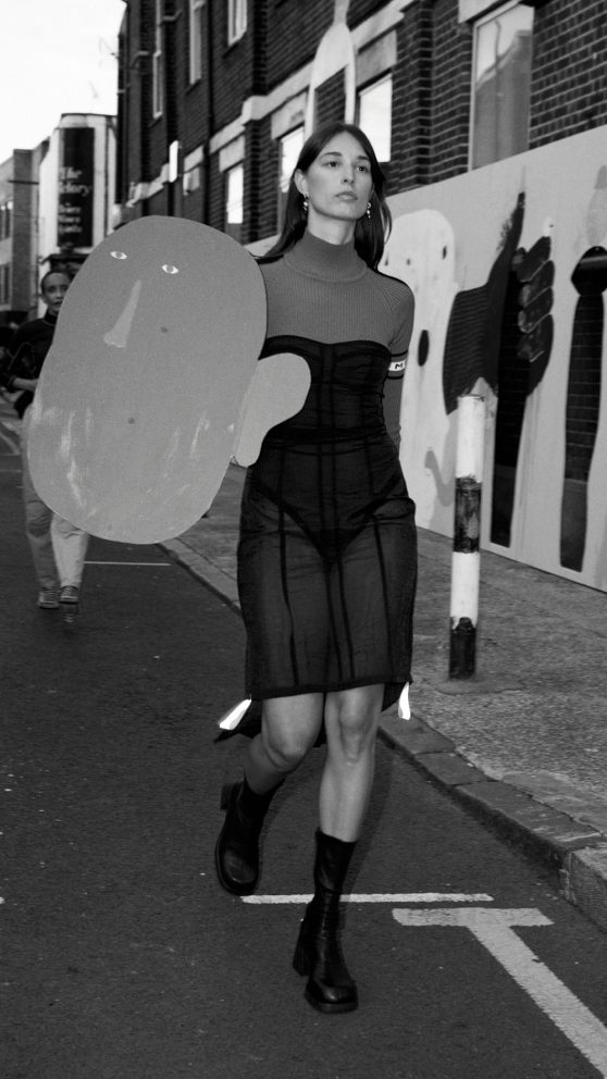 Akti-magdalini Konstantinou walking in the performance artwork / runway fashion show for Miista AW2022. Art by Cristina Reyes. Vyner Street.